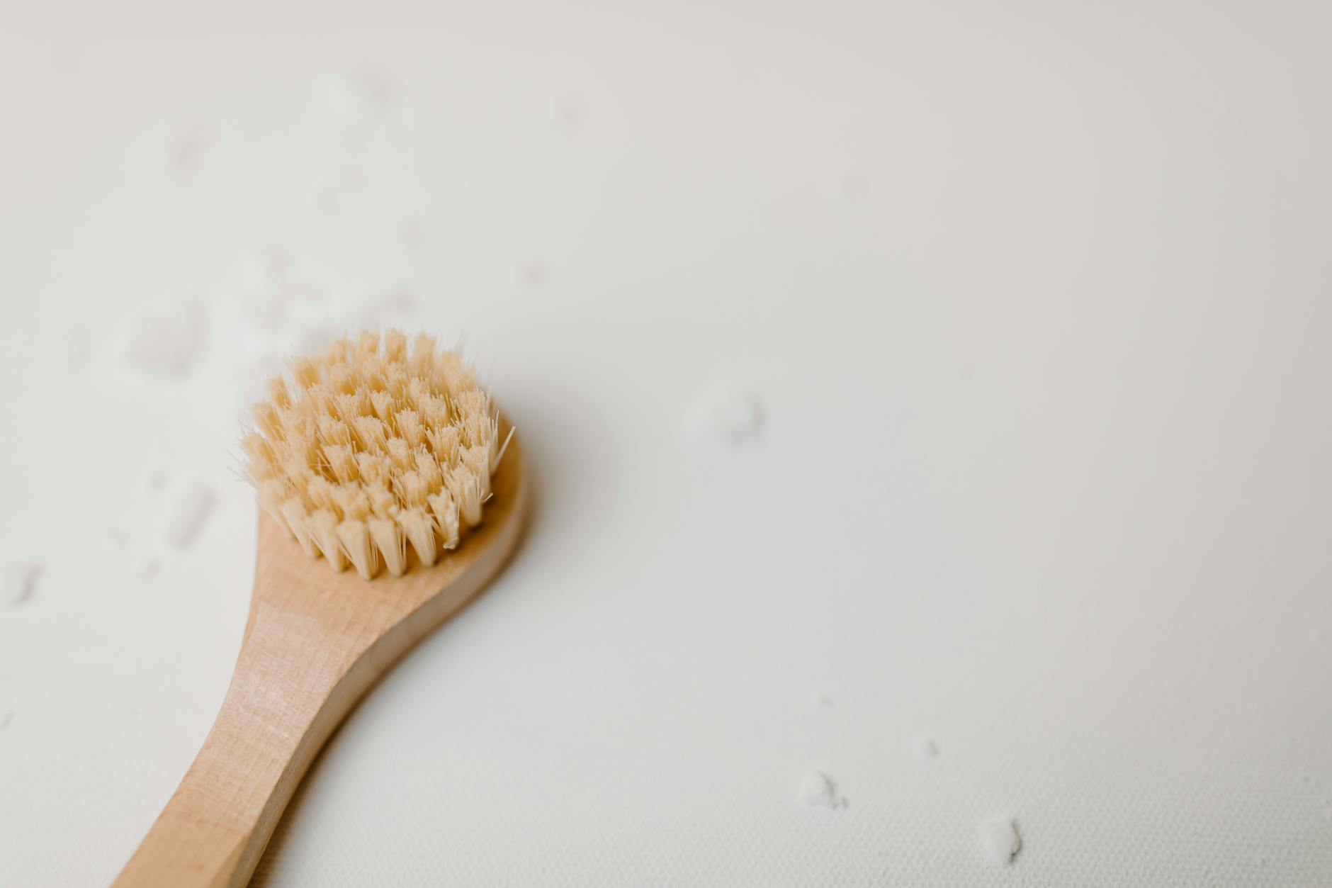 A close-up of a wooden bath brush with a minimalist design, perfect for spa and self-care themes.