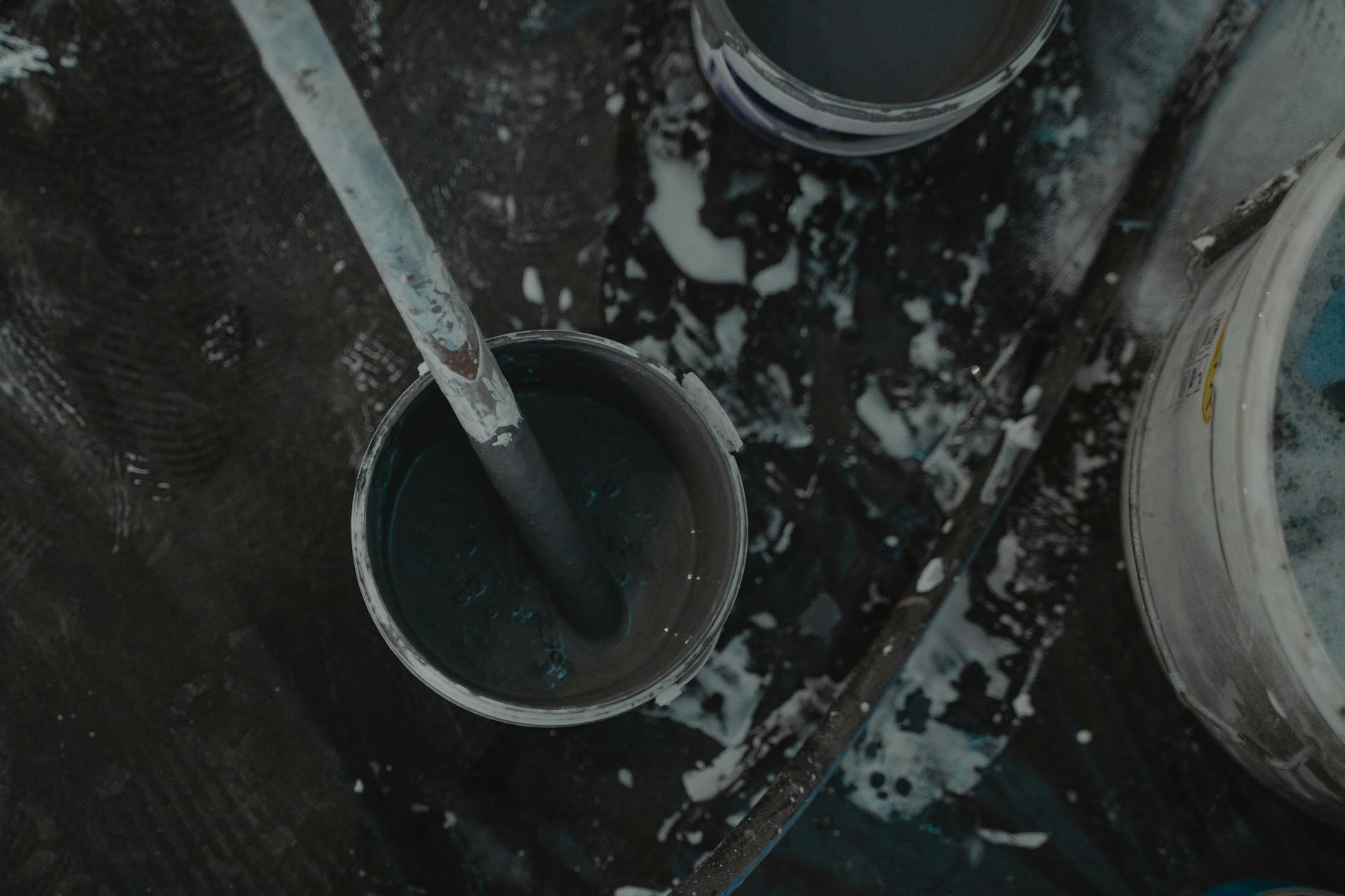 Aerial shot of paint buckets and tools on a construction site, showcasing a renovation project.